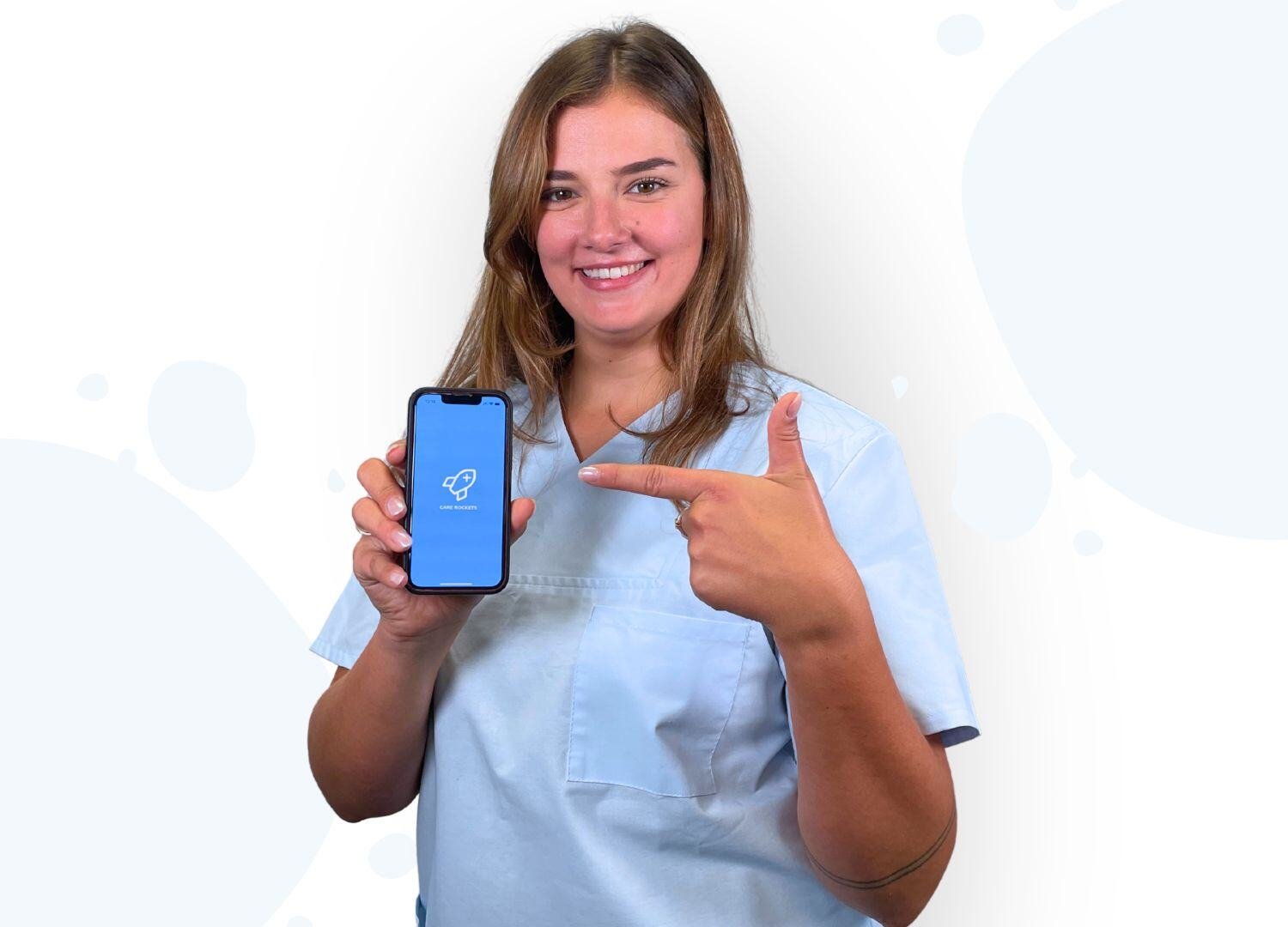 Pflegekraft im weißen Kasack hält ihre Smartphone mit der geöffneten Care Rockets App