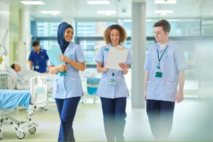 Drei internationale Pflegekräfte im Stationsalltag im Krankenhaus