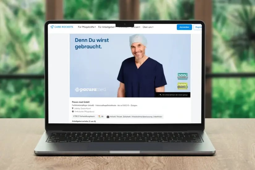 Laptop zeigt die Care Rockets Unternehmensprofil-Webseite mit einer Stellenanzeige, darauf ein lächelnder Mann in blauer OP-Kleidung und Haube.